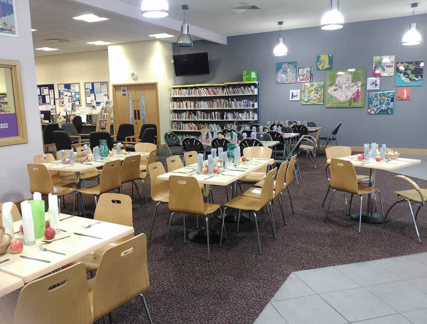 A large room set up with tables for a shared meal
